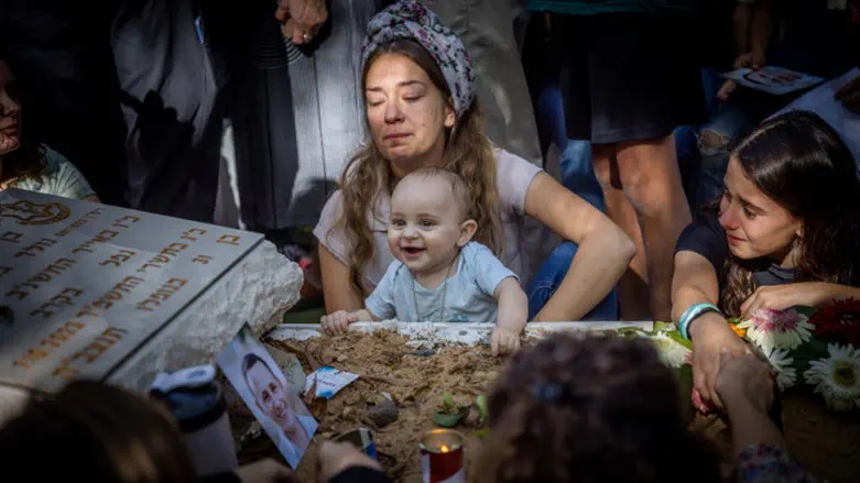 Shaked, eight months old, smiles at his father's grave