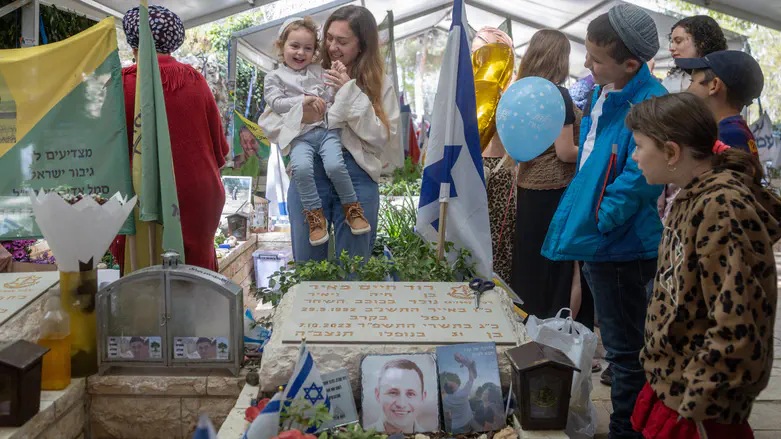 Shaked, three years old, marks his first haircut at his father's grave
